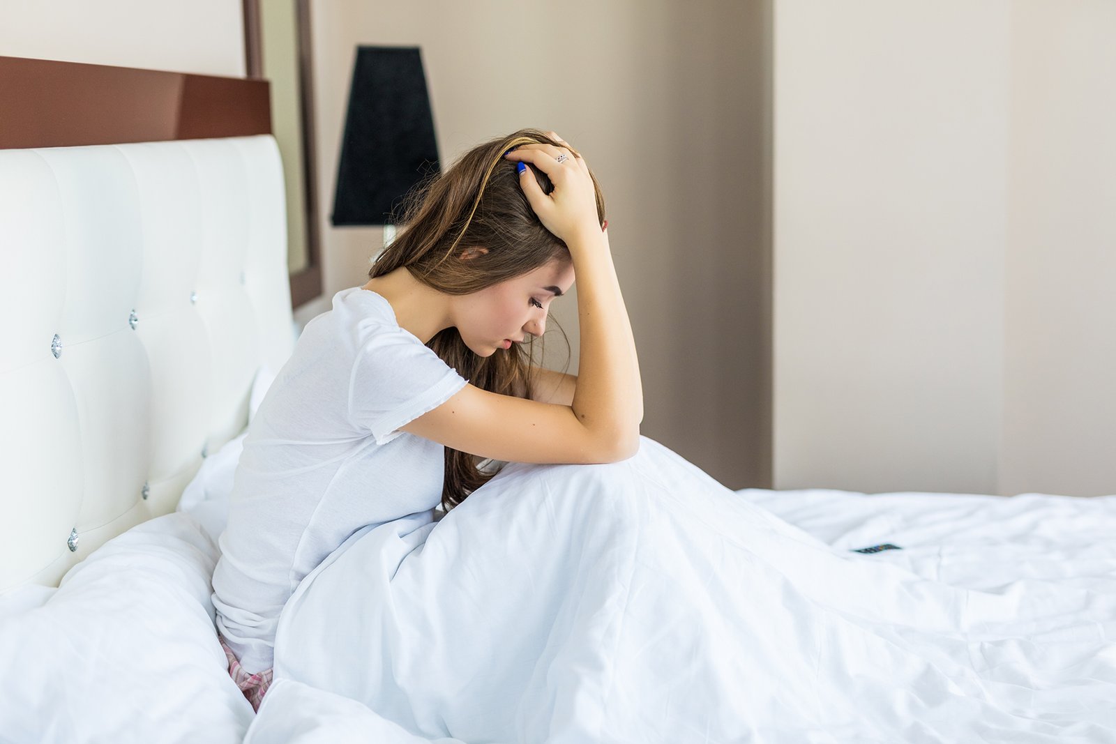 Beautiful woman having a headache sitting in bed